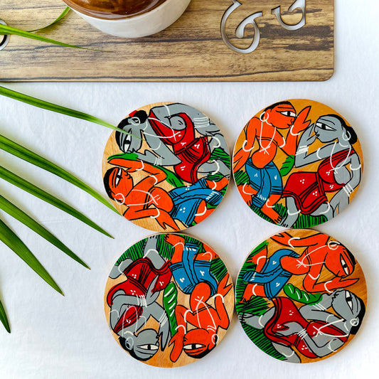 Four pure mango wood round wooden coasters, with a painting of two tribal people dancing at a wedding 