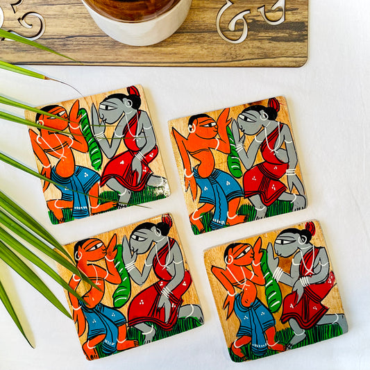 Four pure mango wood square wooden coasters, with a painting of two tribal people dancing at a wedding