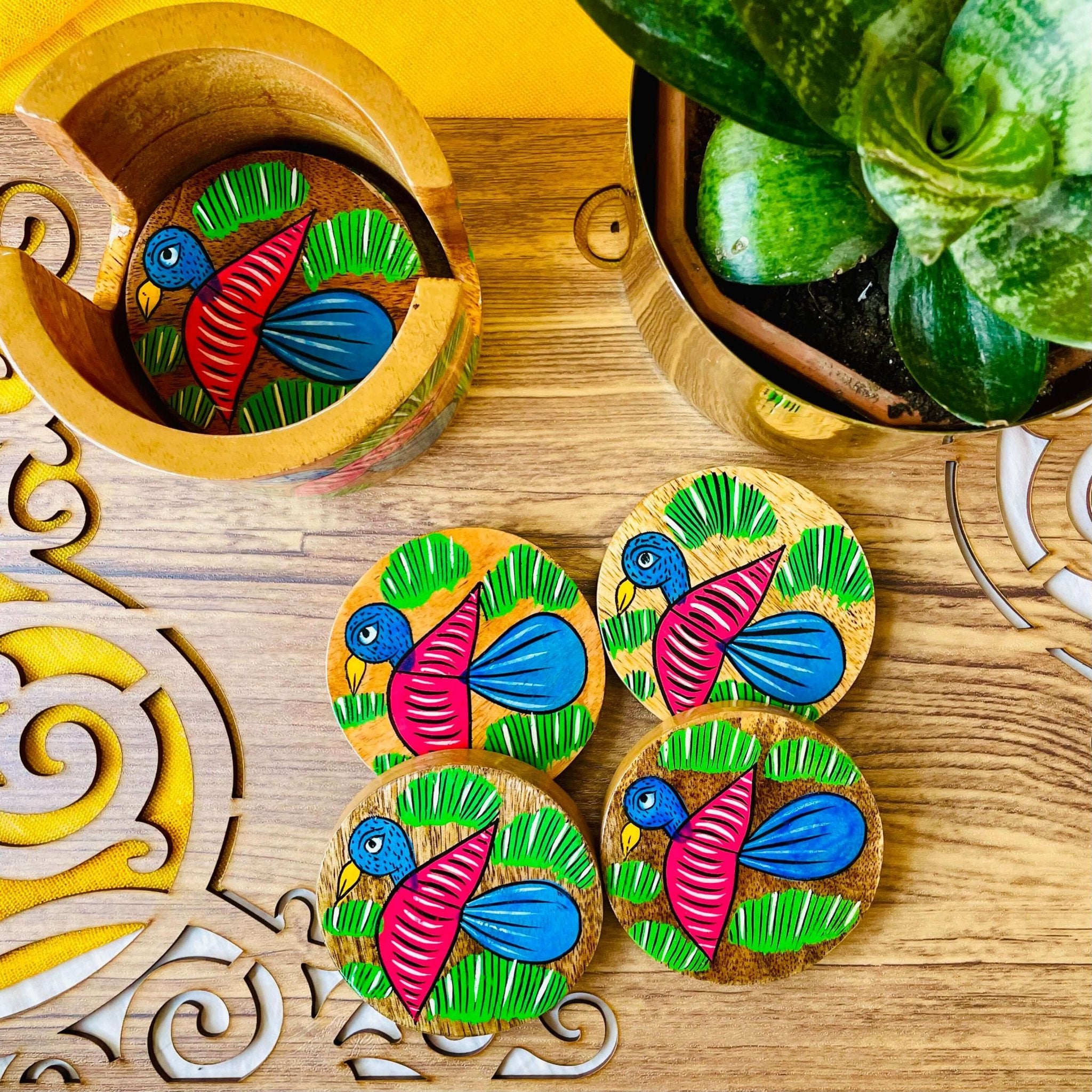 One pure mango wood round wooden coaster is placed in a wood coaster holder while 4 round wooden coasters are displayed near a flower pot.