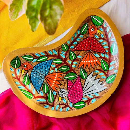 Pure mango wood moon-shaped wooden platter/serving tray hand-painted with birds and tree branch motifs is displayed against a yellow and pink background