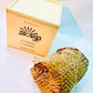 100% natural soy wax scented candle wrapped in honeycomb paper near a wood candle box.