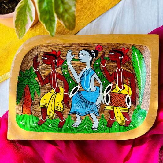Pure mango wood square wood serving tray/trinket tray hand-painted with the motif of two tribal men wearing yellow clothes and a tribal woman wearing a blue dress dancing in a field with a coconut tree