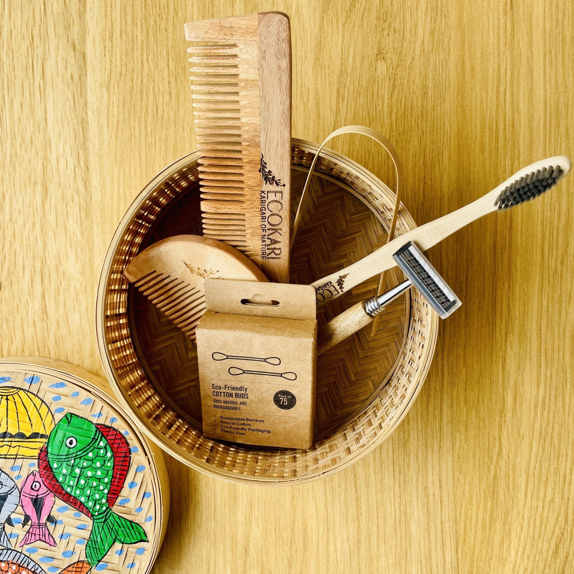 Men's neem wood beard comb, unisex neem wooden comb, cotton bamboo earbuds, tongue cleaner, bamboo toothbrush, bamboo wooden shaving razor packed in a bamboo box hand painted with fish paintings in traditional Pattachitra art form style.