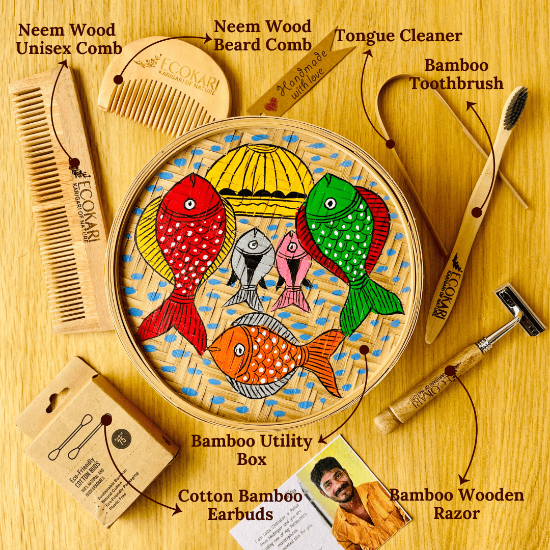 Men's neem wood beard comb, unisex neem wooden comb, cotton bamboo earbuds, tongue cleaner, bamboo toothbrush, bamboo wooden shaving razor displayed around a bamboo box hand painted with fish paintings in traditional Pattachitra art form style.