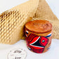 100% natural soy wax scented candle in a terracotta jar hand-painted with red and black fish is covered with terracotta clay candle snuffer and a seed paper candle dust cover and honeycomb paper are placed around the candle