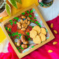 Biscuits, almonds and dates served in a handcrafted pure mango wood square wood tray, painted with two red birds, two blue birds and tea branches by generational Pattachitra artists